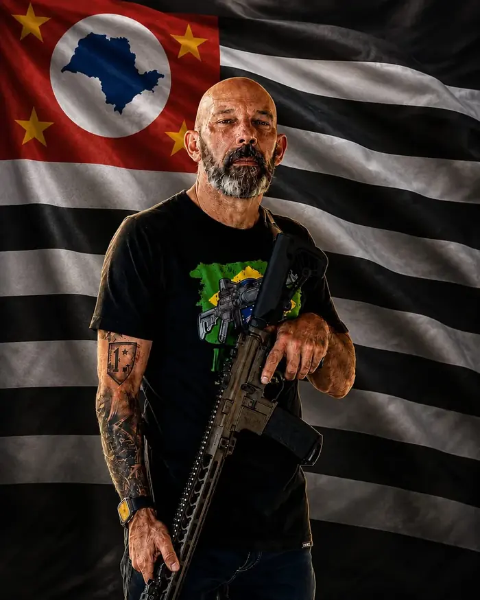Sargento Giroto diante da bandeira do Estado de São Paulo